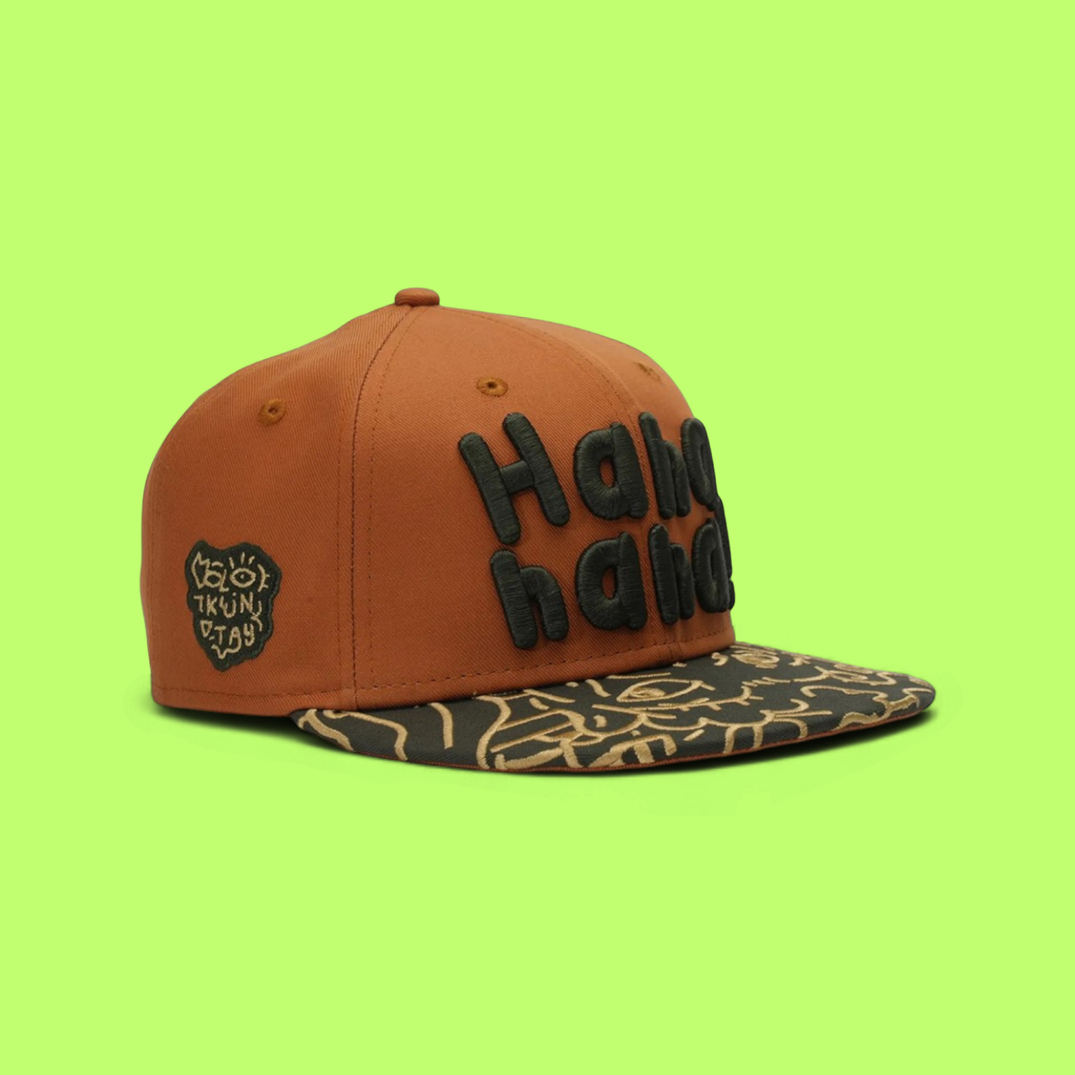 BROWN SNAPBACK CAP WITH GREEN LETTERS AND PATTERNED VISOR